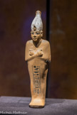Ce chaouabti de Toutânkhamon porte la couronne blanche de Haute-Égypte ornée de l'uræus protecteur. Il joue le rôle de double du roi dans l’au-delà.
Chaouabti en calcaire