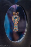 Boucle d’oreille en forme de collier ousekh incrusté d’or avec faucon en verre bleu : une pièce d’une paire
Le faucon, évoquant ici un canard, représente Horus qui tient le symbole chen d’éternité. Le pharaon était l’incarnation terrestred’Horus, fils d'Osiris.
Or, quartz, calcite, faïence égyptienne, verre.